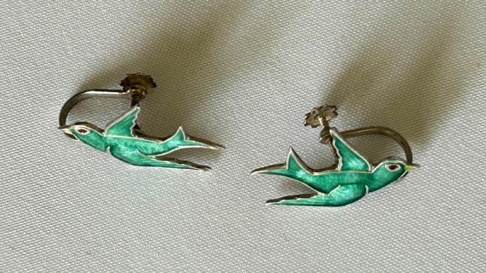 Pair of Edwardian sterling silver earrings shaped as swallows in flight with vibrant green enamel wings and body. View III