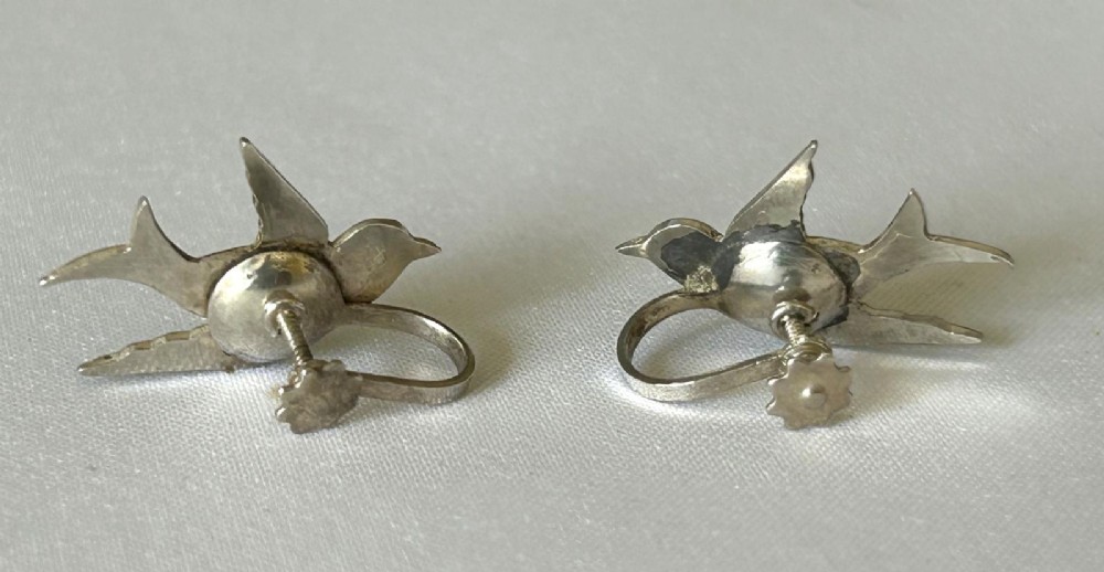 Pair of Edwardian sterling silver earrings shaped as swallows in flight with vibrant green enamel wings and body. View VI