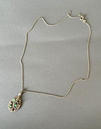 A teardrop-shaped silver pendant featuring textured edges, openwork branch motifs, and three small green chrysoprase cabochons suspended on a fine silver chain. View IV