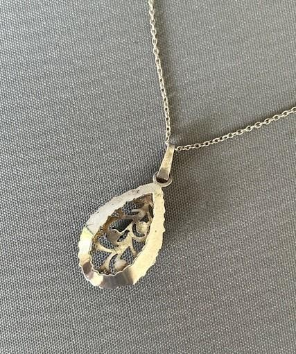 A teardrop-shaped silver pendant featuring textured edges, openwork branch motifs, and three small green chrysoprase cabochons suspended on a fine silver chain. View VIII