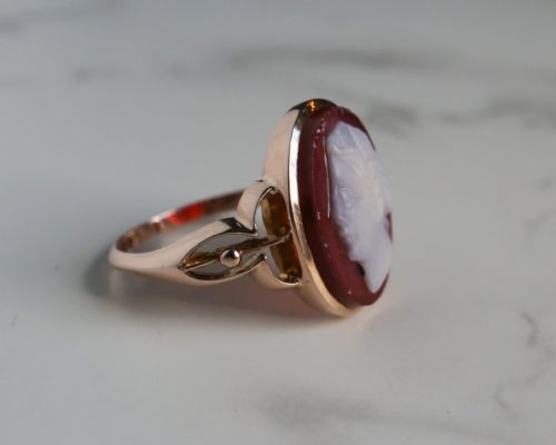 fig 2. An antique nine-carat gold ring featuring an oval relief carving of a classical female profile set against a red background.