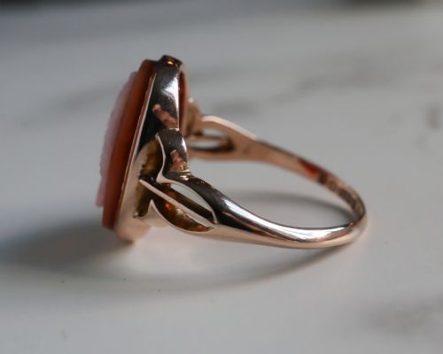 fig 3. An antique nine-carat gold ring featuring an oval relief carving of a classical female profile set against a red background.