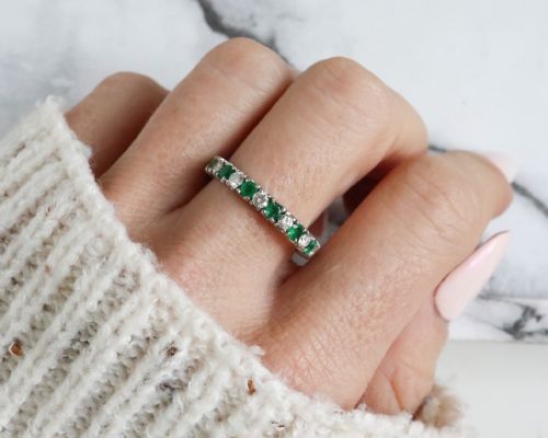 fig 5. An antique platinum full eternity ring set with alternating round green emeralds and white diamonds in a claw setting.