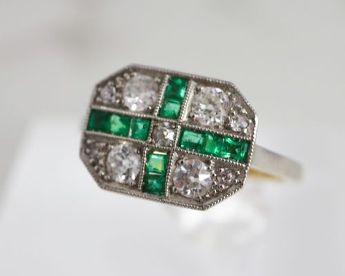 fig 1. An Art Deco rectangular plaque ring featuring a cross motif of green emeralds surrounded by four round diamonds set in platinum on a gold band.