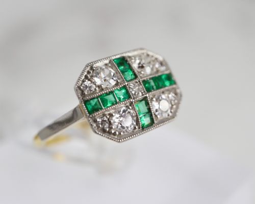fig 3. An Art Deco rectangular plaque ring featuring a cross motif of green emeralds surrounded by four round diamonds set in platinum on a gold band.