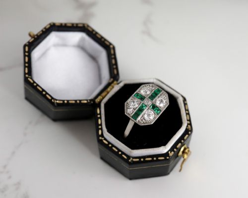 fig 4. An Art Deco rectangular plaque ring featuring a cross motif of green emeralds surrounded by four round diamonds set in platinum on a gold band.