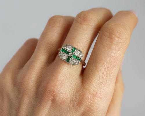 fig 6. An Art Deco rectangular plaque ring featuring a cross motif of green emeralds surrounded by four round diamonds set in platinum on a gold band.