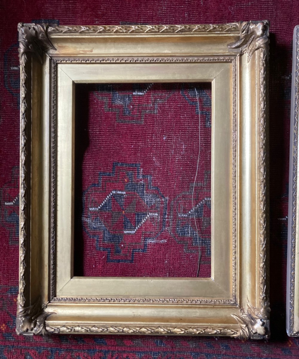 A matching pair of rectangular antique gilt gesso picture frames featuring ornate corner carvings and leaf motif mouldings. View III