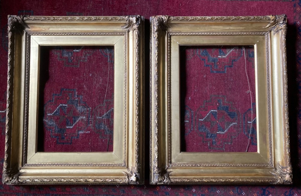 A matching pair of rectangular antique gilt gesso picture frames featuring ornate corner carvings and leaf motif mouldings. View IV