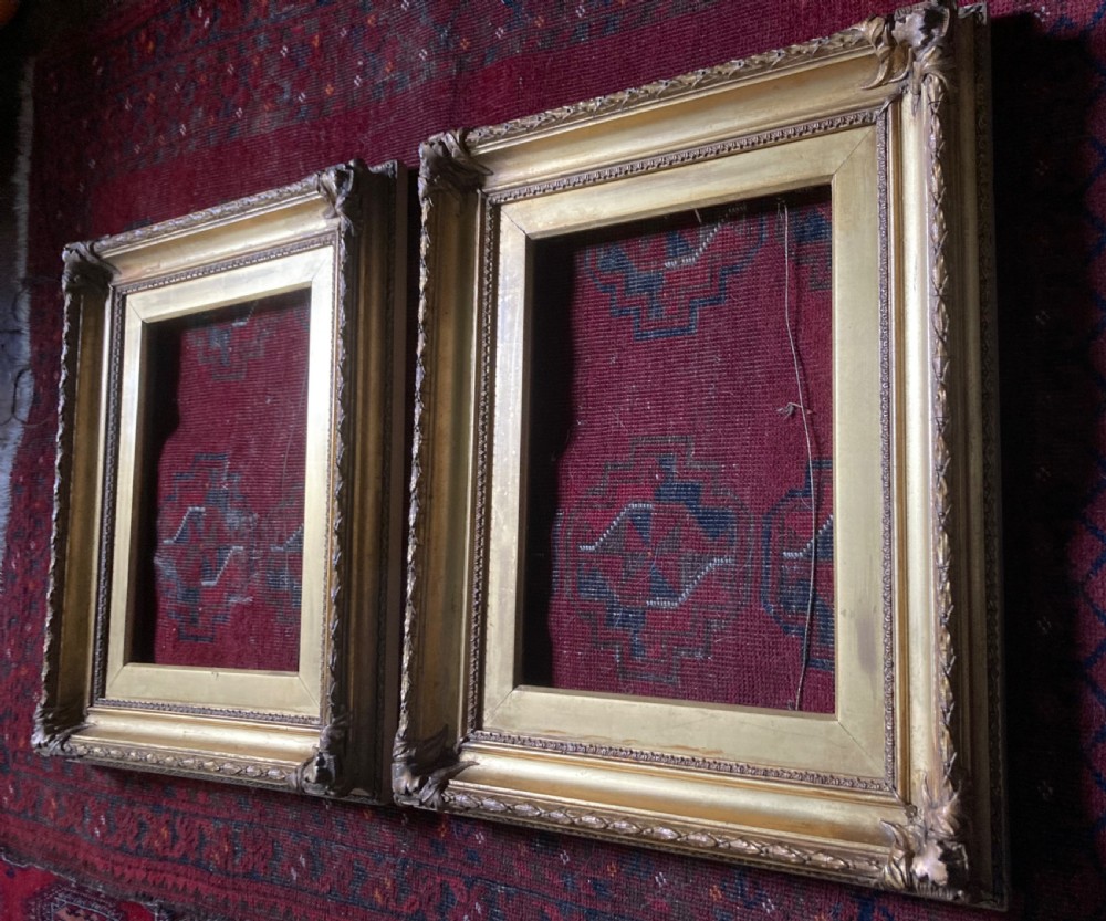 A matching pair of rectangular antique gilt gesso picture frames featuring ornate corner carvings and leaf motif mouldings. View V