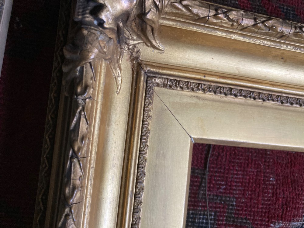 A matching pair of rectangular antique gilt gesso picture frames featuring ornate corner carvings and leaf motif mouldings. View VII