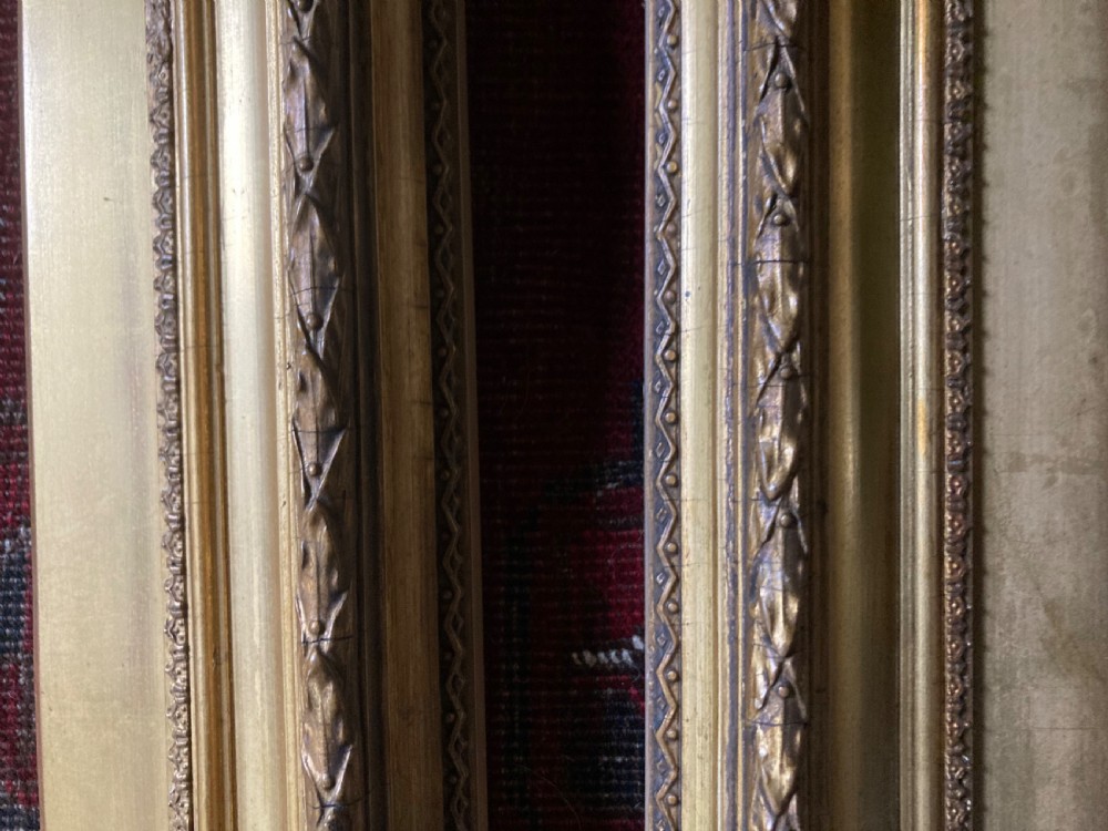 A matching pair of rectangular antique gilt gesso picture frames featuring ornate corner carvings and leaf motif mouldings. View XI