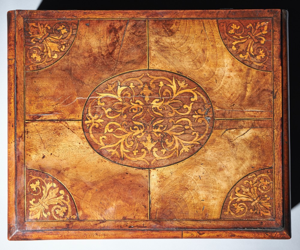 A rectangular seventeenth-century figured walnut box featuring intricate seaweed marquetry in an oval central cartouche and matching corner panels. View II