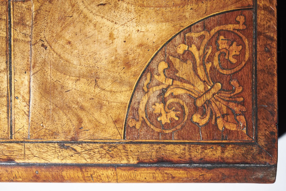 A rectangular seventeenth-century figured walnut box featuring intricate seaweed marquetry in an oval central cartouche and matching corner panels. View X