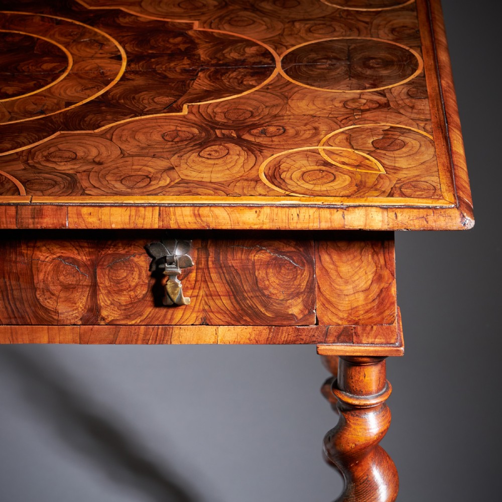 A late 17th-century William and Mary side table featuring intricate olive wood oyster veneering, barley-twist legs, an X-frame stretcher, and a frieze drawer. View IV