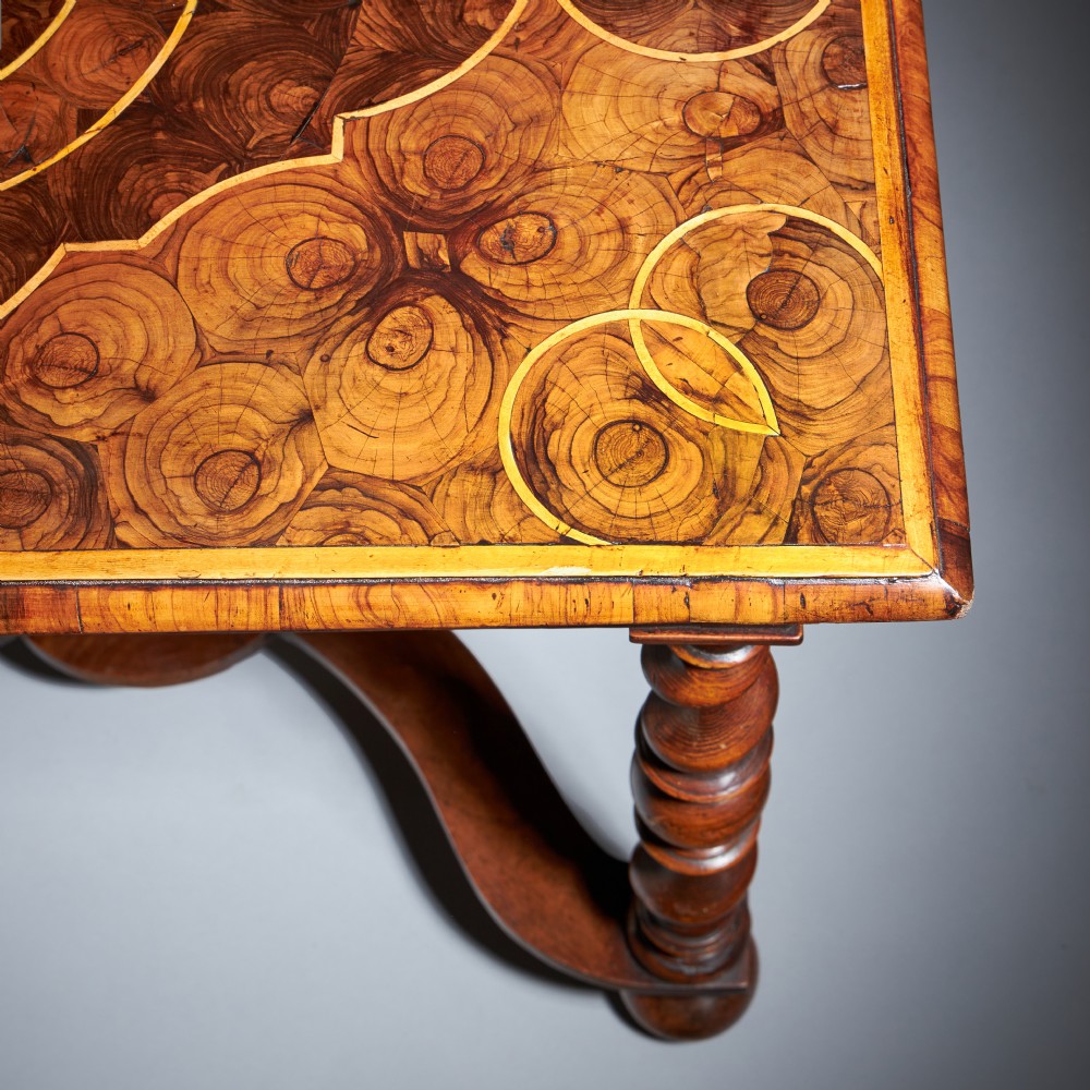 A late 17th-century William and Mary side table featuring intricate olive wood oyster veneering, barley-twist legs, an X-frame stretcher, and a frieze drawer. View V