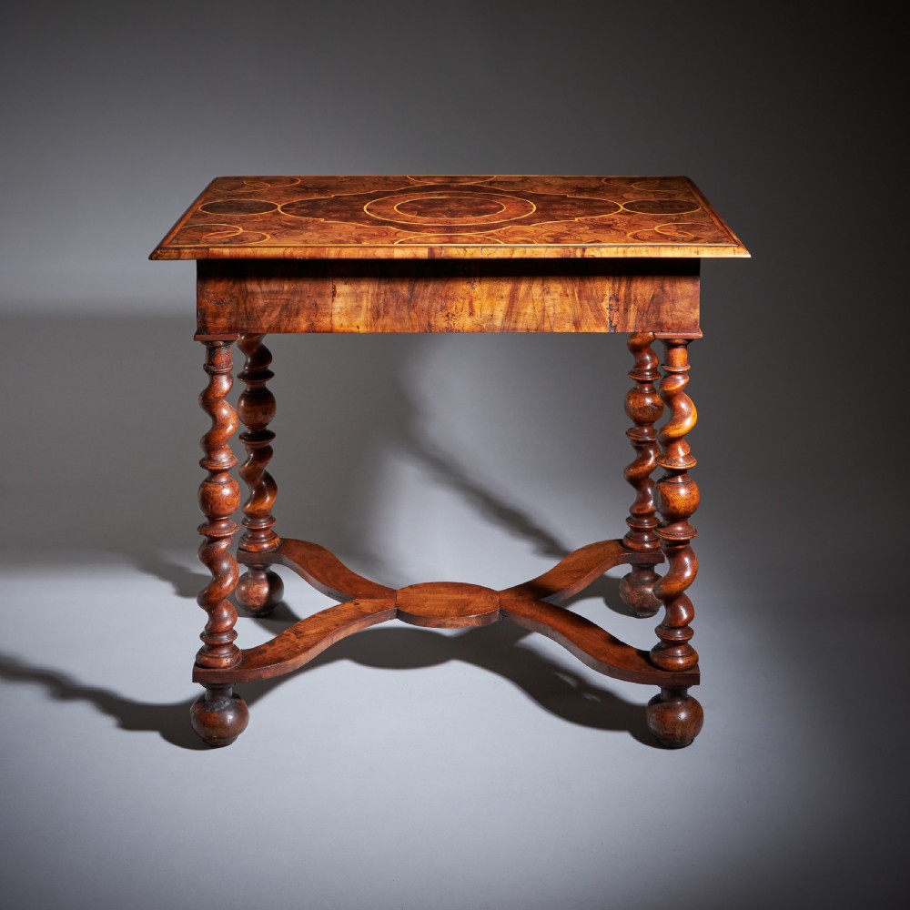 A late 17th-century William and Mary side table featuring intricate olive wood oyster veneering, barley-twist legs, an X-frame stretcher, and a frieze drawer. View XIV
