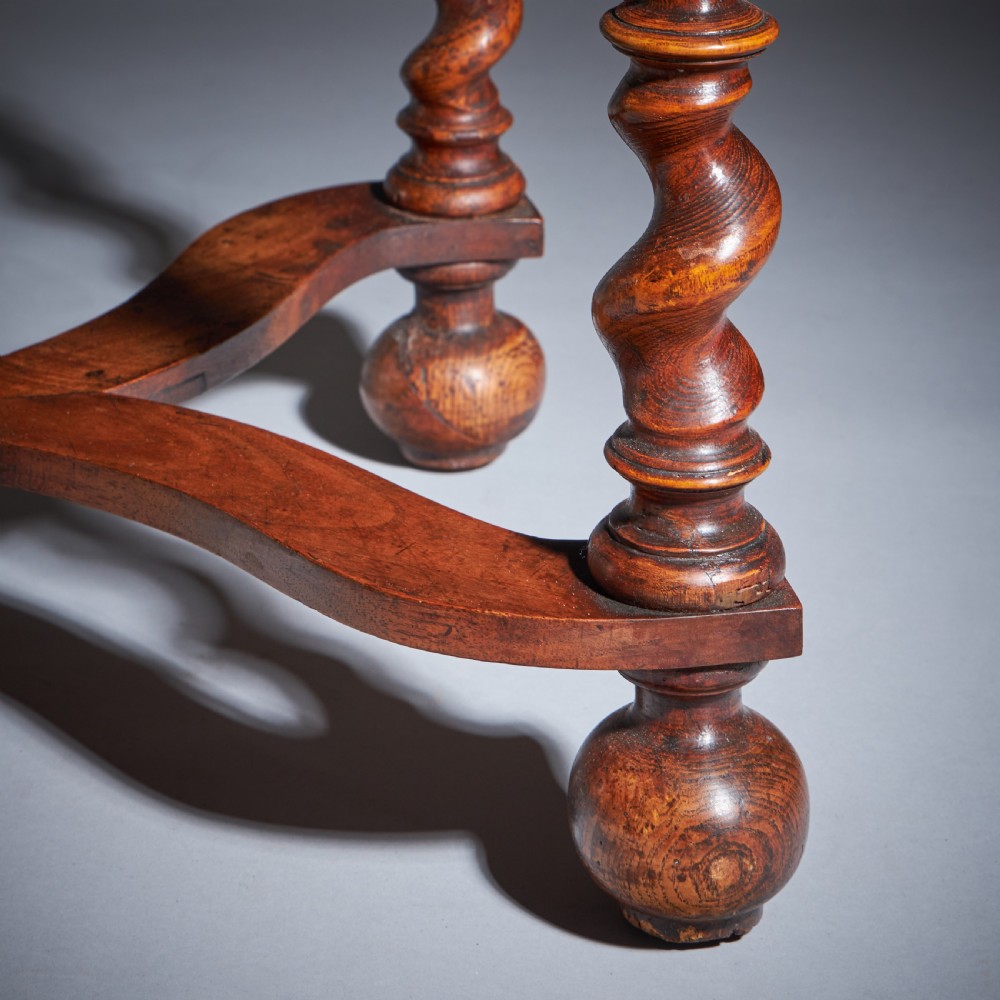A late 17th-century William and Mary side table featuring intricate olive wood oyster veneering, barley-twist legs, an X-frame stretcher, and a frieze drawer. View XVI