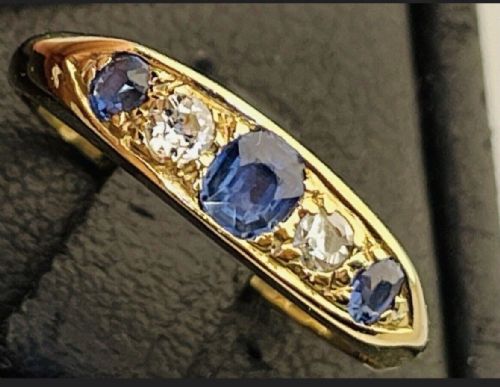 fig 3. An Edwardian 18ct yellow gold ring set with three blue sapphires alternating with two white diamonds in a carved bridge setting.
