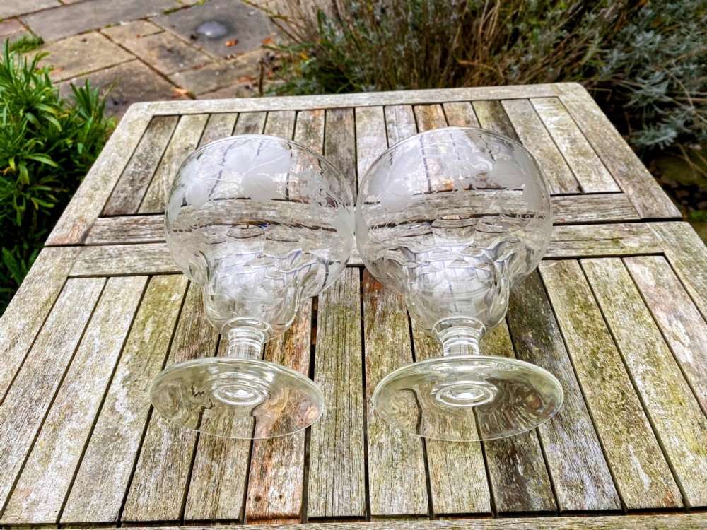 A pair of clear glass rummers decorated with etched grapevine motifs around the wide bowls and short stems. View III