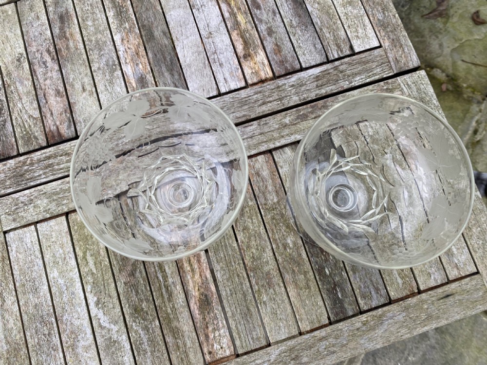 A pair of clear glass rummers decorated with etched grapevine motifs around the wide bowls and short stems. View IV