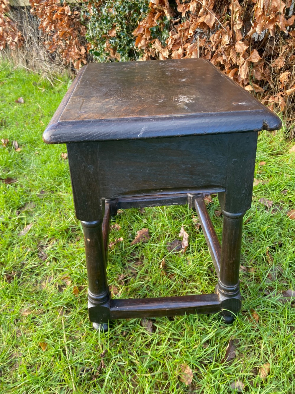 A dark oak joint stool featuring a rectangular top, rectangular frame apron, four turned legs, and low perimeter stretchers. View VI