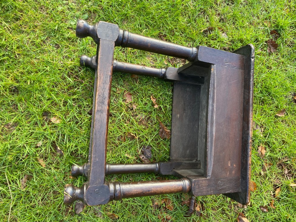 A dark oak joint stool featuring a rectangular top, rectangular frame apron, four turned legs, and low perimeter stretchers. View IX