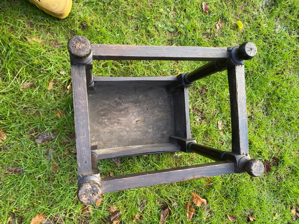 A dark oak joint stool featuring a rectangular top, rectangular frame apron, four turned legs, and low perimeter stretchers. View X