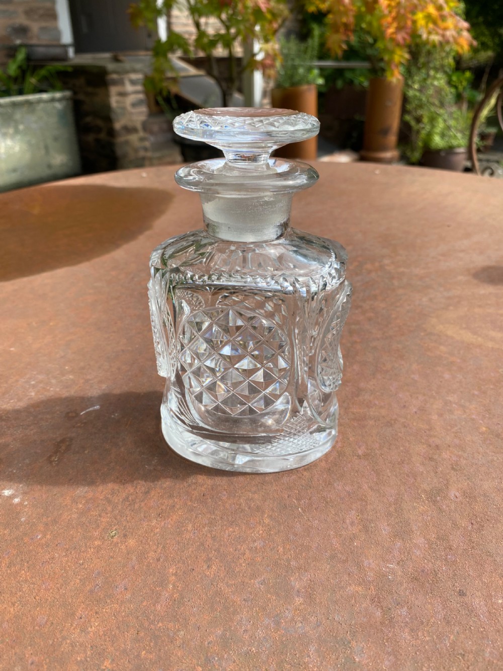 A clear 19th-century cut glass spirit decanter featuring diamond-patterned relief carvings and a fitted circular cut stopper. View III