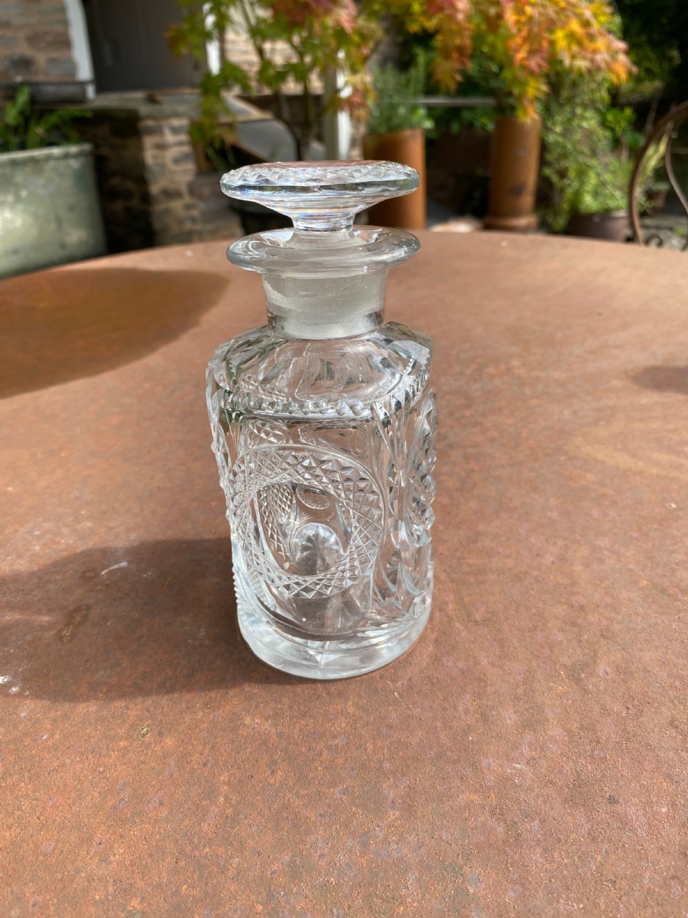 A clear 19th-century cut glass spirit decanter featuring diamond-patterned relief carvings and a fitted circular cut stopper. View IV