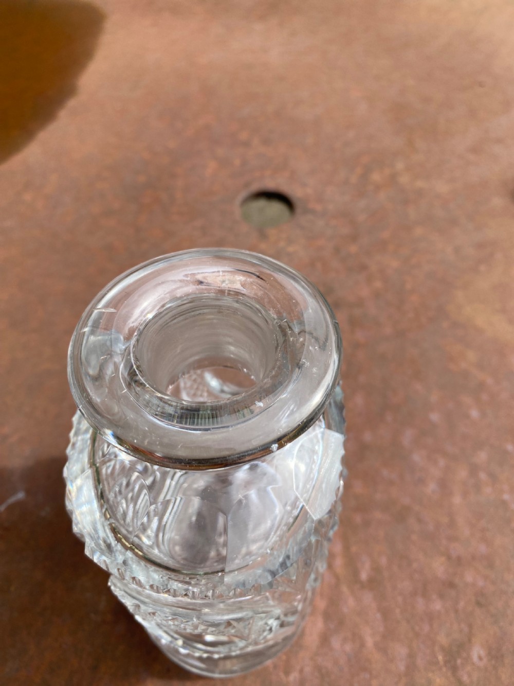 A clear 19th-century cut glass spirit decanter featuring diamond-patterned relief carvings and a fitted circular cut stopper. View VI