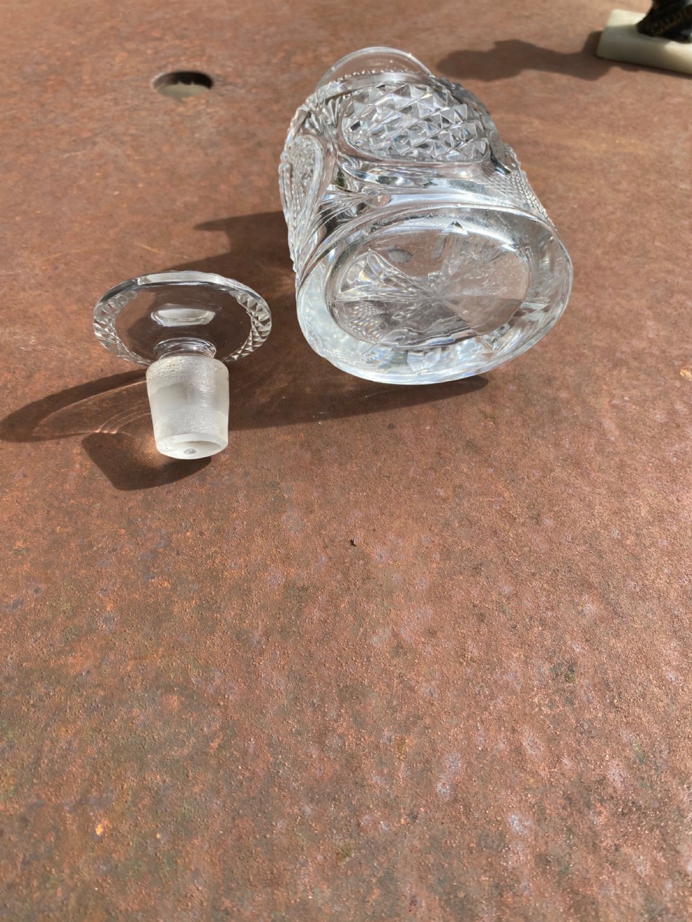 A clear 19th-century cut glass spirit decanter featuring diamond-patterned relief carvings and a fitted circular cut stopper. View VII
