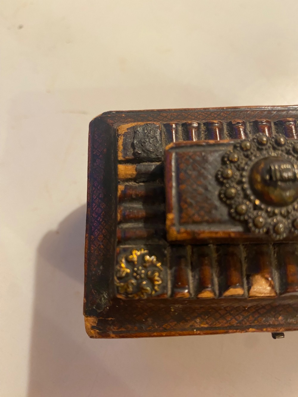 An antique dark brown tooled leather trinket box featuring a tiered lid with decorative brass mounts, brass hook clasp, and round ball feet. View XI