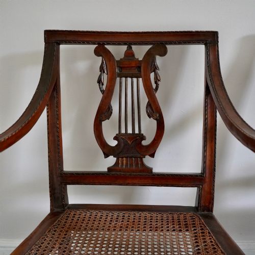 fig 2. A matching pair of 19th-century Regency style mahogany armchairs featuring carved lyre back splats and woven cane seats.