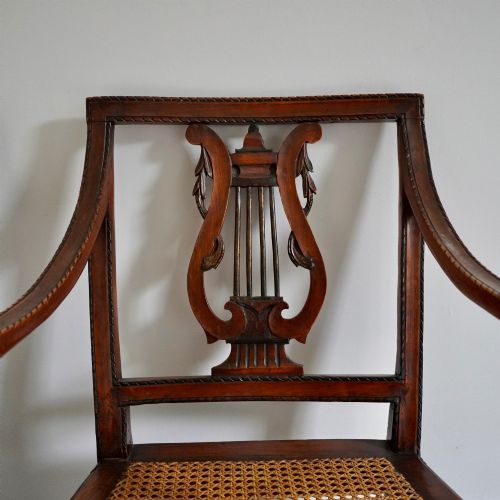 fig 3. A matching pair of 19th-century Regency style mahogany armchairs featuring carved lyre back splats and woven cane seats.