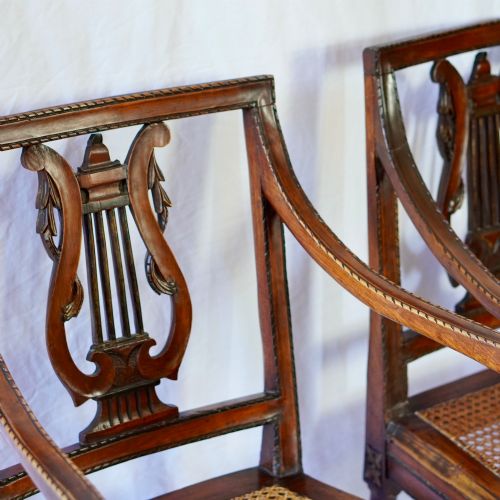 fig 4. A matching pair of 19th-century Regency style mahogany armchairs featuring carved lyre back splats and woven cane seats.