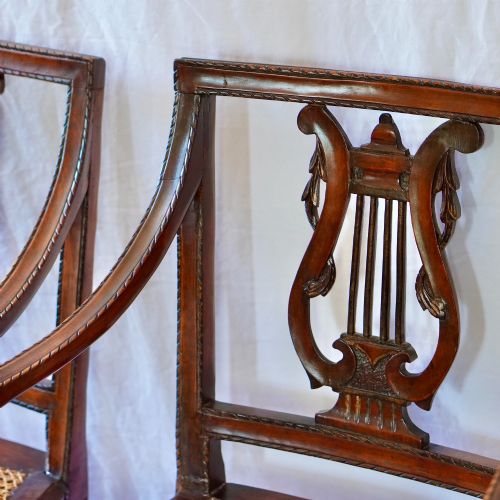 fig 7. A matching pair of 19th-century Regency style mahogany armchairs featuring carved lyre back splats and woven cane seats.