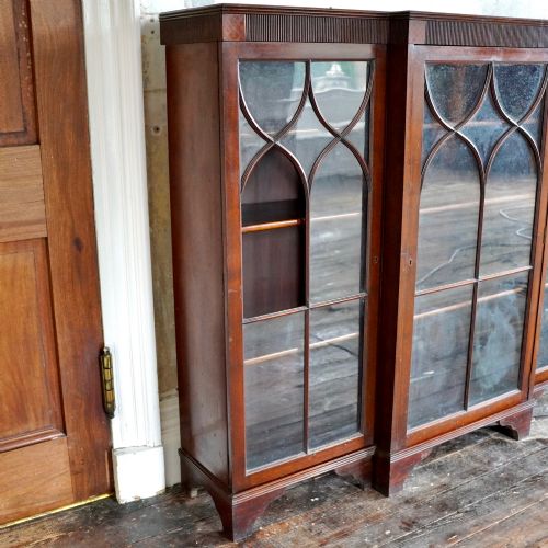 fig 2. A large Victorian dark mahogany breakfront glazed bookcase featuring three doors with Gothic arch astragal glazing bars and a fluted cornice.