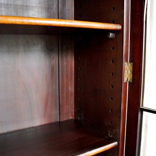 fig 7. A large Victorian dark mahogany breakfront glazed bookcase featuring three doors with Gothic arch astragal glazing bars and a fluted cornice.