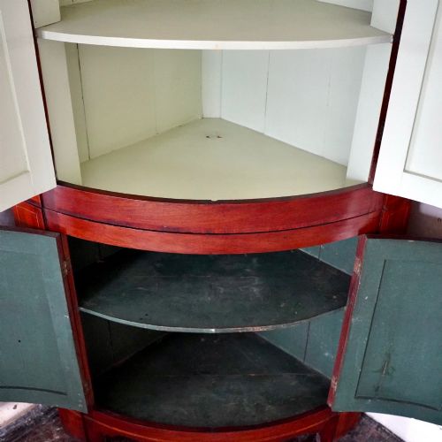 fig 4. A tall Georgian mahogany bowfront corner cupboard featuring two upper curved doors, two lower curved doors, and fine line inlay.