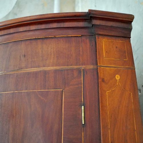 fig 7. A tall Georgian mahogany bowfront corner cupboard featuring two upper curved doors, two lower curved doors, and fine line inlay.