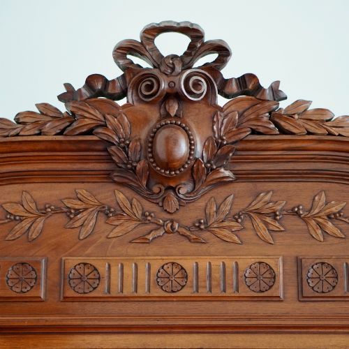 fig 1. A tall 19th-century Continental open wooden bookcase featuring an ornate carved pediment, fluted side columns, panelled back, and multiple adjustable shelves.