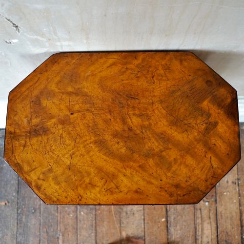 fig 4. An octagonal George III satinwood work table with two drawers, lion mask ring handles, and tapered legs ending in brass castors.
