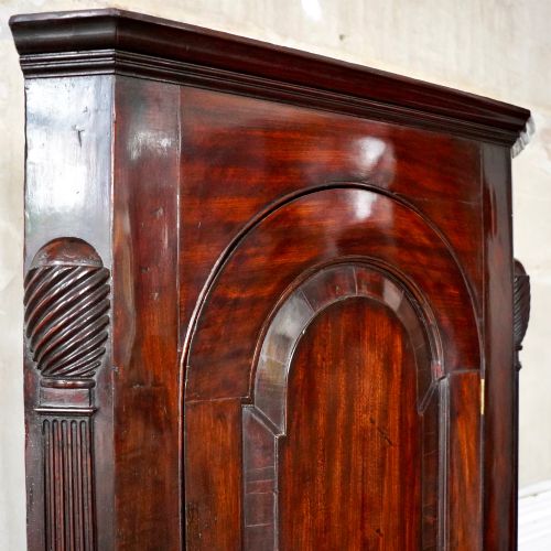 fig 6. Mid-18th century Georgian mahogany hanging corner cupboard featuring an arched panelled door, brass hardware, and fluted pilasters.