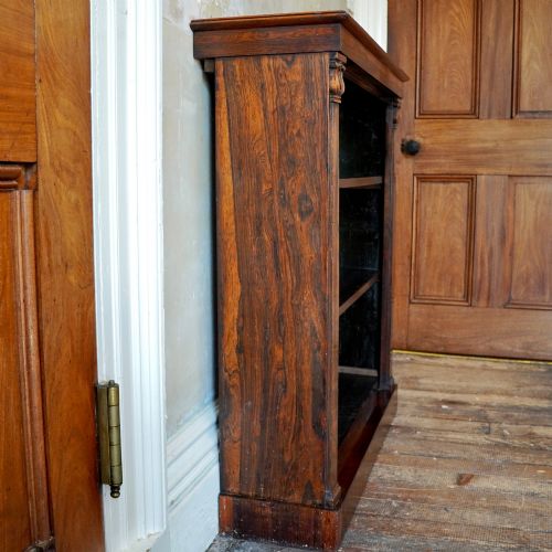 fig 2. An antique William IV rosewood open bookcase featuring two adjustable shelves, a solid plinth base, and carved scroll capitals atop side pilasters.