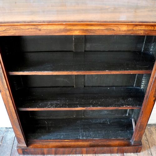 fig 4. An antique William IV rosewood open bookcase featuring two adjustable shelves, a solid plinth base, and carved scroll capitals atop side pilasters.