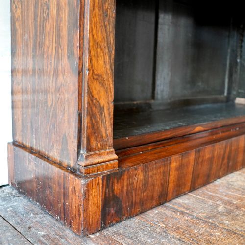 fig 6. An antique William IV rosewood open bookcase featuring two adjustable shelves, a solid plinth base, and carved scroll capitals atop side pilasters.