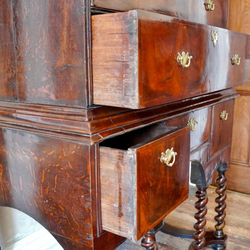 fig 6. A George I period figured walnut chest on stand featuring engraved brass escutcheons and six barley-twist legs.
