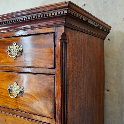 fig 5. A late 18th-century George III mahogany chest on chest featuring brass swan-neck handles, keyhole escutcheons, dentil moulding, and bracket feet.