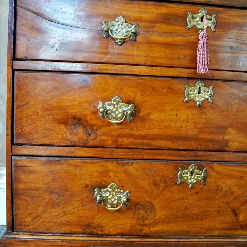 fig 7. A late 18th-century George III mahogany chest on chest featuring brass swan-neck handles, keyhole escutcheons, dentil moulding, and bracket feet.